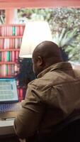 Vertical Business analyst calculating project funds and analytics at his home, allocating resources and solving tasks to accomplish objectives. Entrepreneur works on money management accounting. Camera B. video