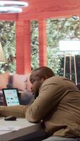 Vertical Entrepreneur falling asleep while he is calculating the annual sales reports to review the budget, feeling exhausted and fatigued working from home. Businessman with burnout. Camera B. video