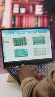 Vertical Entrepreneur calculating expenses with online invoices on laptop, creating an analytics reports plan for investment strategy. Working on increasing budget for business expansion. Camera A. video