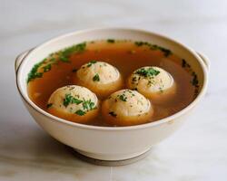 a bowl of soup with three dumplings in it photo