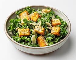 a bowl of kale salad with tofu cubes in it photo