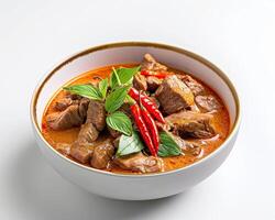 a bowl of beef and curry with a red sauce photo