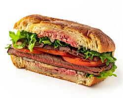 a sandwich with meat and vegetables on a white surface photo
