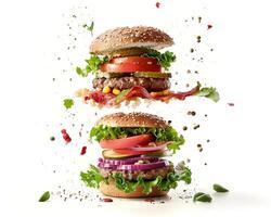 Two hamburgers with toppings flying in the air photo