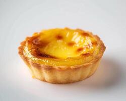 A small pastry with a yellow top on a white surface photo