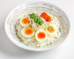a bowl of noodles with eggs and vegetables photo