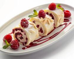 a roll of cake with raspberries and cream on it photo