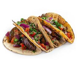 three tacos with vegetables on a white surface photo