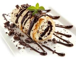 a roll of chocolate cake with chocolate sauce and mint photo