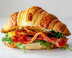 a croissant sandwich with bacon and lettuce photo