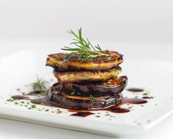 a stack of eggplant with a drizzle of balsamic vinegar photo