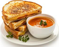 a plate topped with a grilled cheese sandwich and a bowl of soup photo