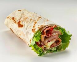a wrap with meat and lettuce on a white surface photo