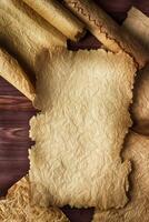Crumpled scroll on wooden background, empty space for text photo