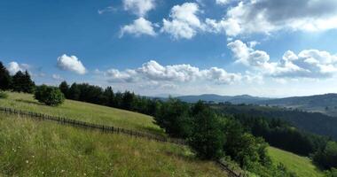 Aerial view of mountain peaks and fresh green grass on a sunny summer day video