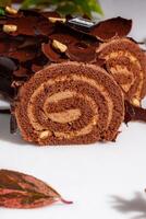 Sliced log-shaped chocolate roll with buttercream and hazelnuts photo