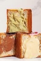 Pyramid of halves of cube croissants with pistachio cream, vanilla custard and chocolate filling photo