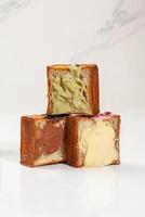Three halved cube croissants with vanilla custard, light pistachio and chocolate cream photo