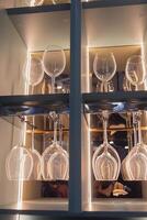 Shelf with many empty glasses in evening light photo