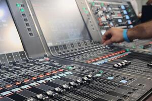 Sound engineer hands adjusting control sound mixer in recording, broadcasting studio photo