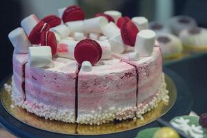 Beautiful delicious cake with marshmallow and macarons on a store window photo