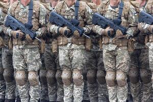A line of soldiers in camouflage uniforms with a machine gun and insignia of the Ukrainian army photo