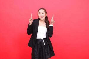 gesture of cheerful young Asian office woman wearing black formal suit both hands pointing up, for corporate content, fashion, advertising, broadcast photo