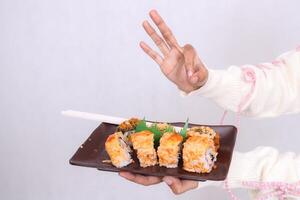 a plate closeup and front angle containing a sushi dish Japanese food a delicious delicious okay gesture held by a woman's hand for culinary, food and lifestyle content photo