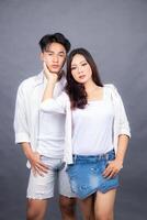 man and woman posing standing in front of camera hands holding cheeks indoor man. promotional couple photo session in the studio