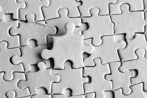 Scattered White Puzzle Pieces on Plain Background with . photo