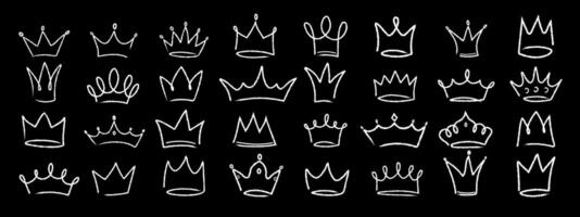 Hand drawn linear grunge set of crowns on black background. Collection of royal diadems sketches drawn in white chalk on black board. illustration vector