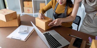 Asian women managing shipping logistics for online business. Concept of e-commerce operations, teamwork, and order fulfillment photo