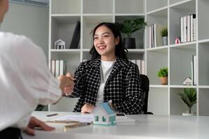 Real estate agents and customers shake hands to congratulate on signing a contract to buy a house with land and insurance, handshake and good response concept photo