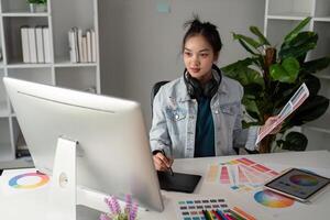 UX designer. Work on creative applications. Man with a palette in his hands. Designer applies the primary colors to the monitors. Development of a training application. Designer is a freelancer photo