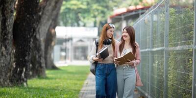 University student girl friends with learning book college while walking in campus photo