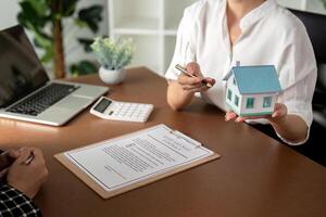 Real estate agent talking about the terms of the home purchase agreement and the customer to signing the documents to make the contract legally, Home sale and home insurance photo