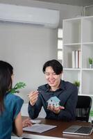 Real Estate Agent Signing Documents with Client for Buy or Sell Property in Modern Office Setting photo