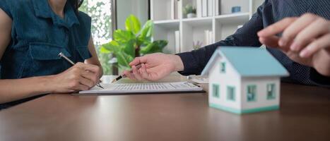 Real Estate Agent Assisting Client with Signing Documents for Buy or Sell a House photo