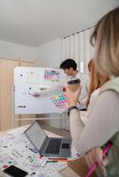 Creative UX Developer and UI Designer Brainstorming Session with Color Palettes and Wireframes in Modern Office photo