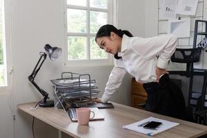 Businesswoman Experiencing Back Pain at Work, Office Worker Struggling with Discomfort, Workplace Health Issues, Ergonomic Problems, Stress and Physical Strain in Modern Office Environment photo