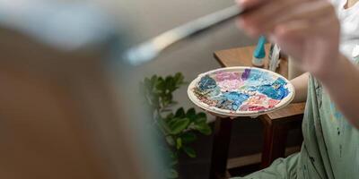Artist Painting in Workshop with Colorful Palette and Brush, Creative Studio Environment, Artistic Process, Close Up of Hand and Paint, Inspiring Art Scene, Professional Painter at Work photo