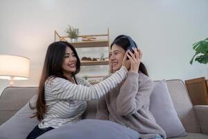 Lesbian Couple Relaxing at Home, Enjoying Quality Time Together on the Couch, Listening to Music and Sharing a Happy Moment photo