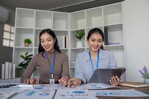 Two Business Professional Discussing Planning and Analysis in a Modern Office Setting with Charts and Graphs photo