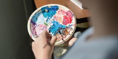 Artist in Workshop Creating Colorful Painting on Palette, Close Up of Hands Mixing Paints, Creative Process in Art Studio, Professional Painter at Work, Artistic Expression, Vibrant Colors, Fine Arts photo