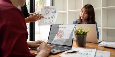 Business Team Analysis Financial Data and Discuss Strategy in Modern Office Setting with Laptops and Charts photo