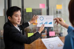 Business Team Discuss Analysis with Charts and Graphs in Modern Office Setting photo