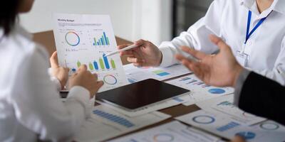 Business Team Discuss Analysis and Planning During a Meeting with Charts and Graphs on the Table photo
