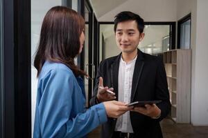 Business Team Discuss Analysis in Modern Office Setting with Digital Tablet and Professional Attire photo