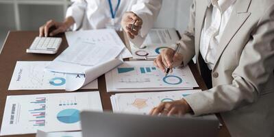 Business Teamwork Planning and Analysis Discussion with Charts and Graphs in Modern Office Setting photo