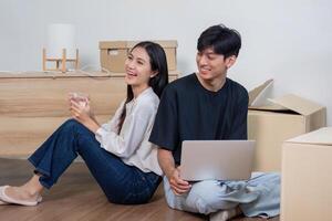 Happy Couple Relaxing in Their New Home Surrounded by Moving Boxes, Enjoying a Break During the Moving Process photo
